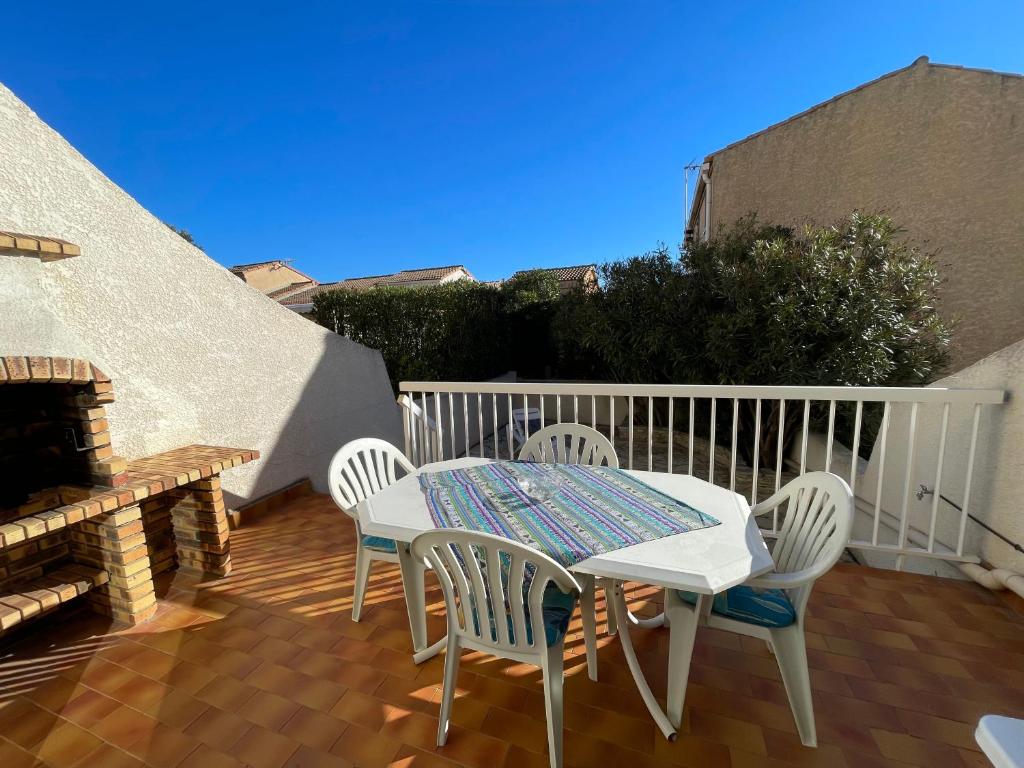 a patio with a table and chairs on a deck at La Maison sur la côte in Fleury