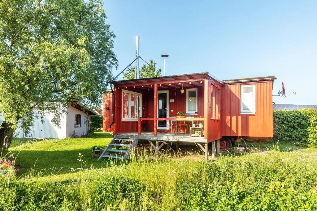 a red tiny house sitting in a field at Tiny House im Grünen in Jesberg