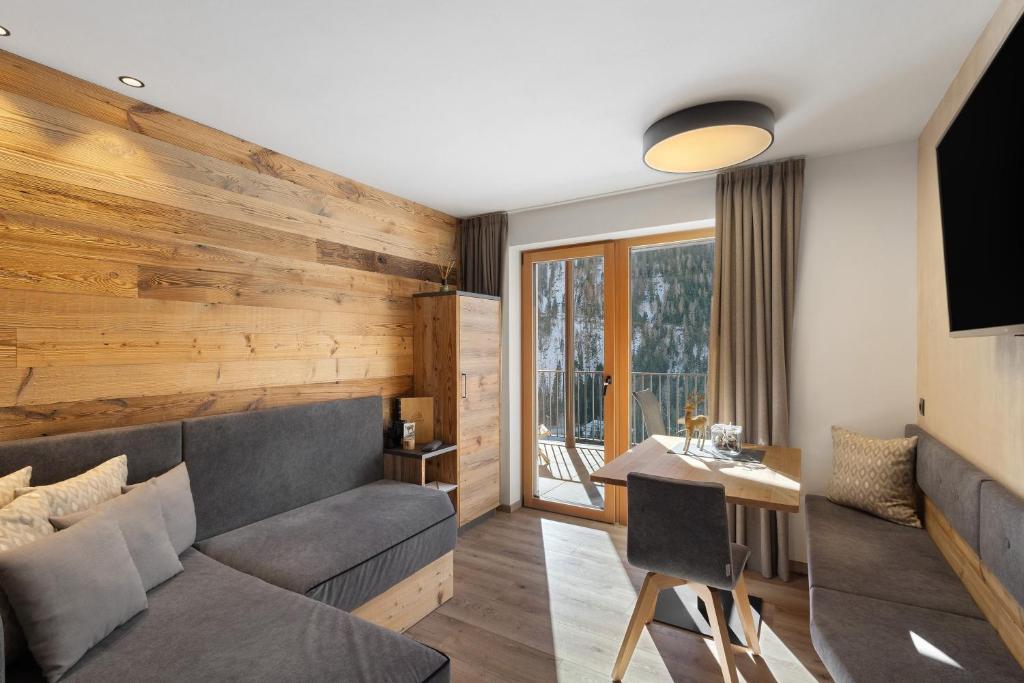 a living room with a couch and a table at Chalet-Suite Wiese in Selva dei Molini