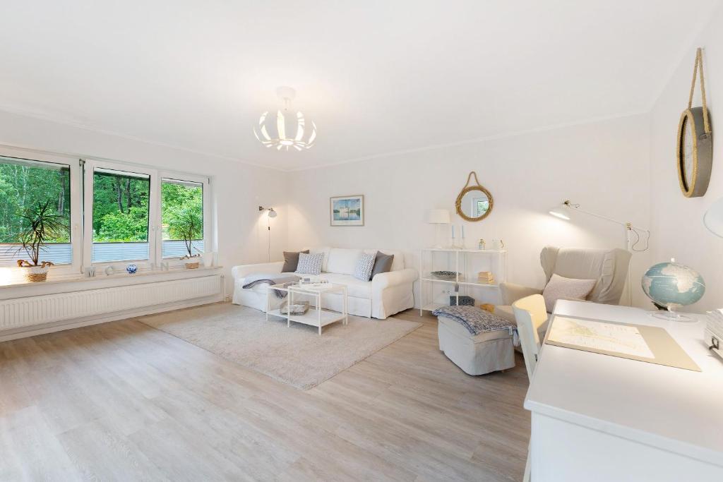 a living room with white furniture and windows at Ferienwohnung Angeln in Ulstrupfeld