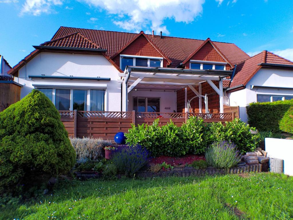 a house with a fence in the yard at Hörselberg Apartment in Hörselberg-Hainich