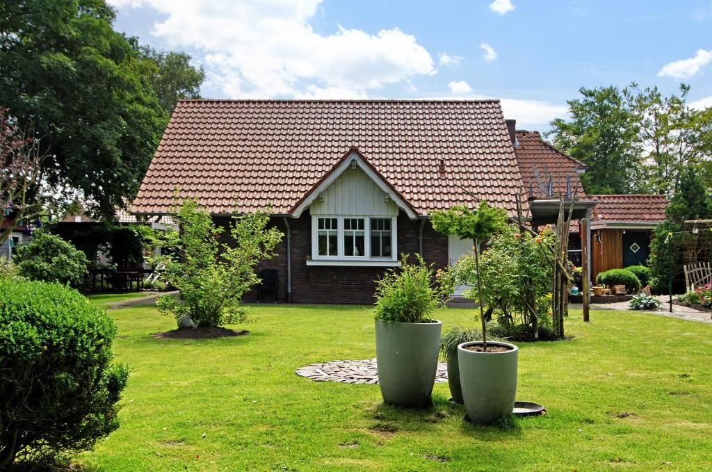 a house with two potted plants in the yard at Seeschwalbe Hilgenriedersiel in Hagermarsch
