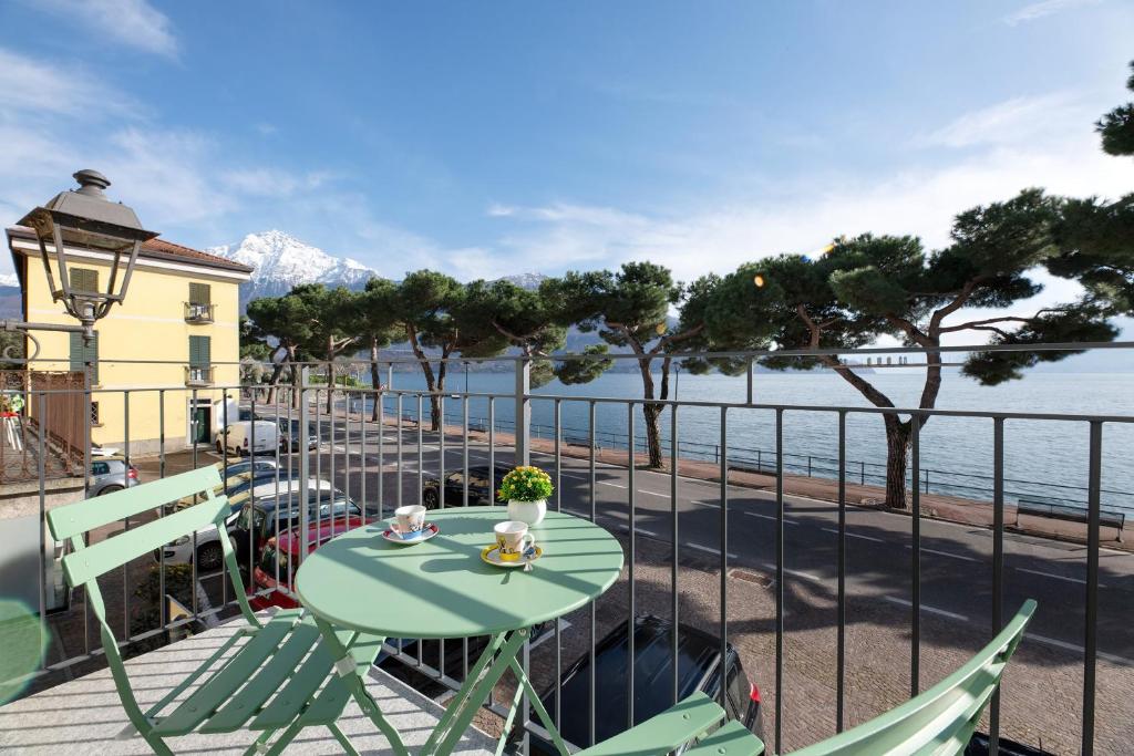 a table and chairs on a balcony with a view of the ocean at Lake view Domaso in Domaso