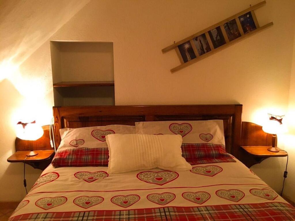 a bedroom with a bed with two lamps and two pillows at Maison Perruchon in Pont-Saint-Martin