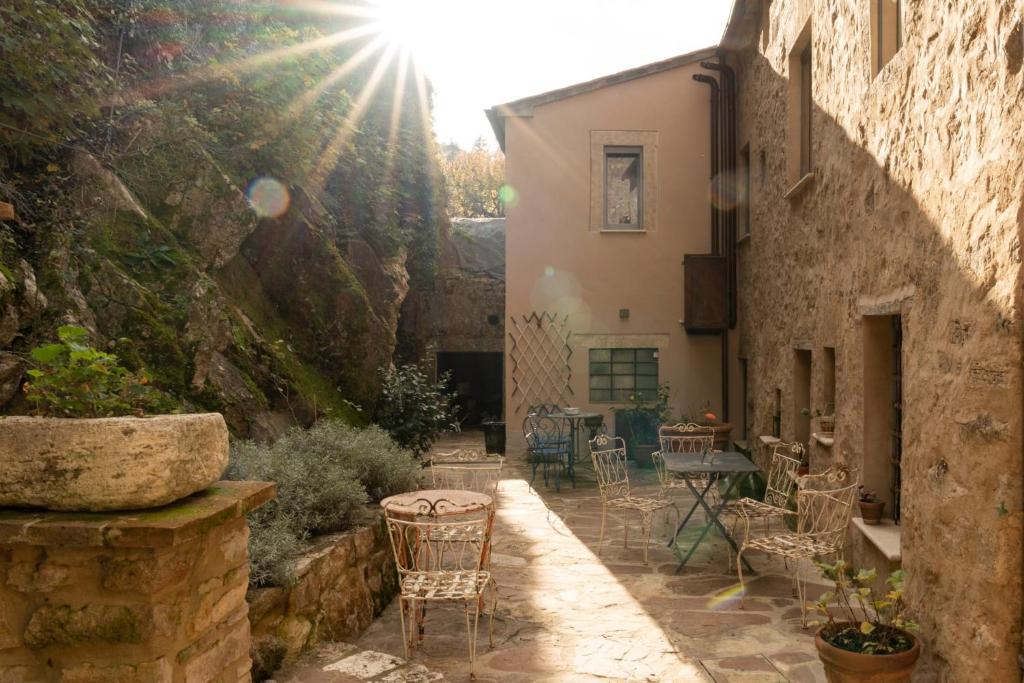 a courtyard with chairs and a table in a building at L'imbrunire in Campiglia dʼOrcia