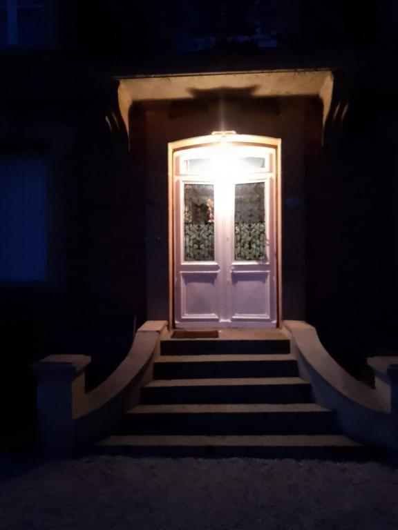 a door with a light at the top of the stairs at BB des 6 arcs"" in Coulonces
