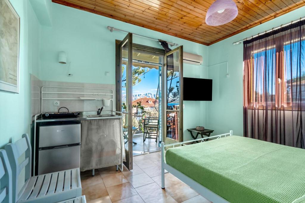 a bedroom with a bed and a kitchen and a balcony at Old Boat double studio 11 in Nikiana