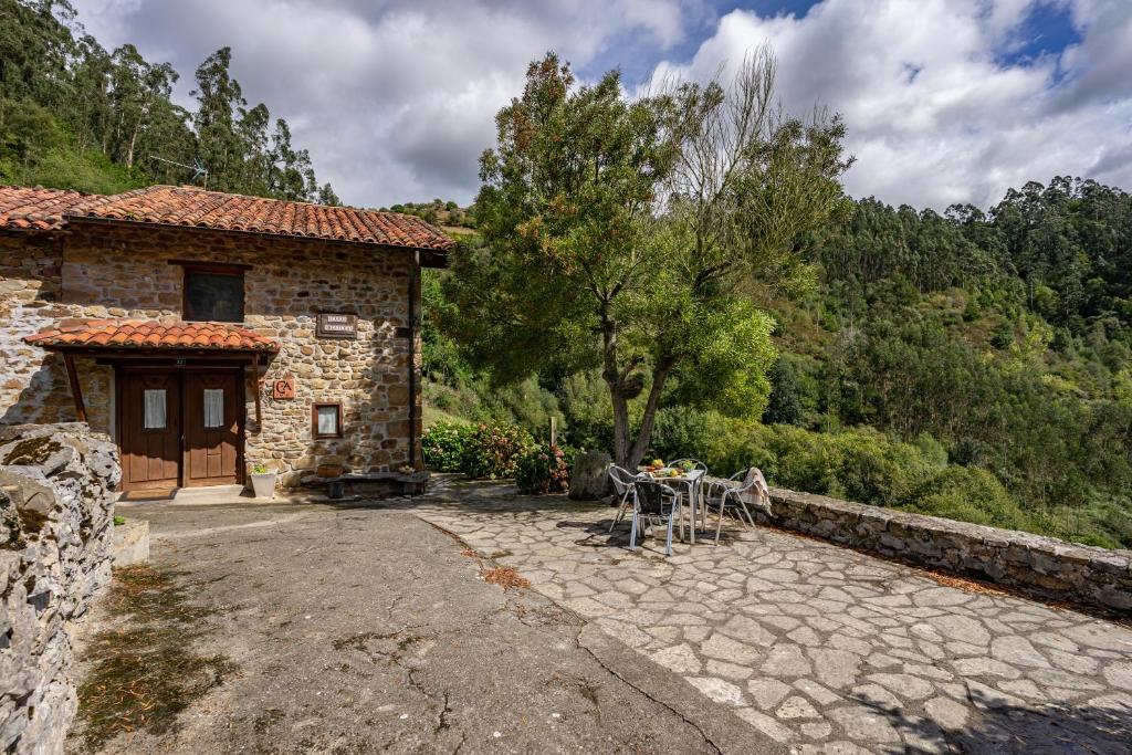 a stone house with a table and chairs in front of it at Casa Mesilda in Para