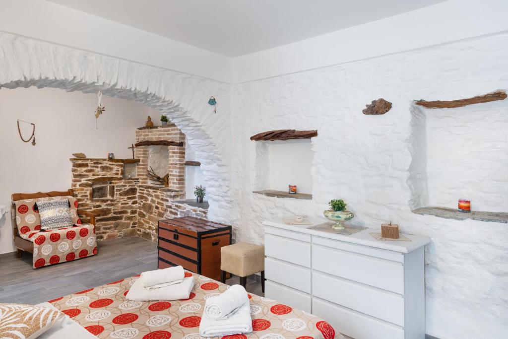 a bedroom with two beds and a stone wall at Olga's House kythnos D in Kithnos