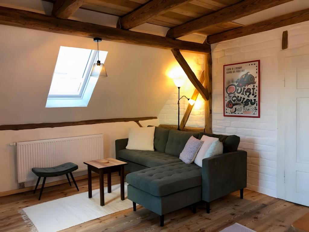 a living room with a green couch and a window at Mein Ferienhaus Rosenbusch 2 in Kemmern