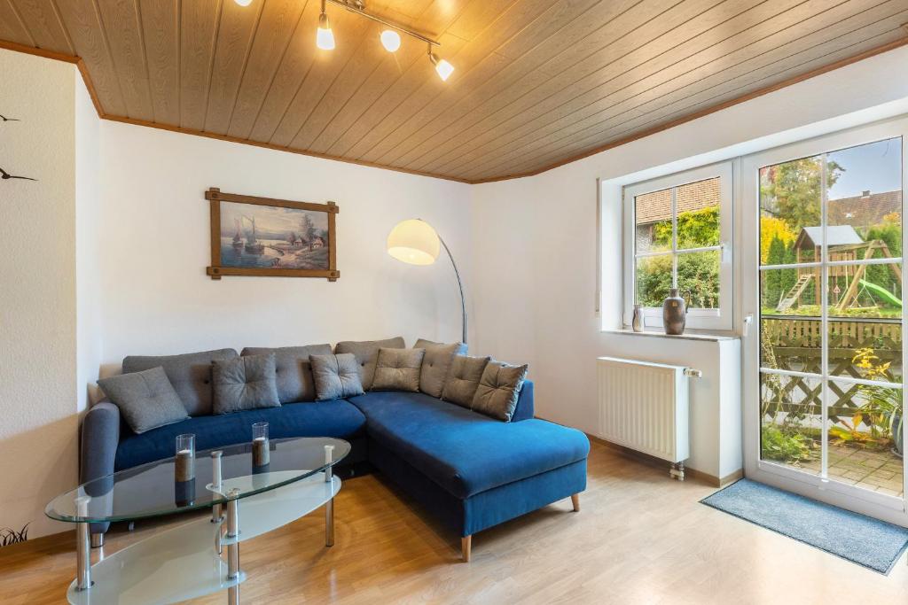 a living room with a blue couch and a table at Ferienwohnung Schönhals in Herbstein