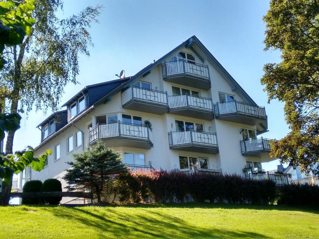 a large white building with balconies on it at Fewo Ricken am Kurpark in Willingen