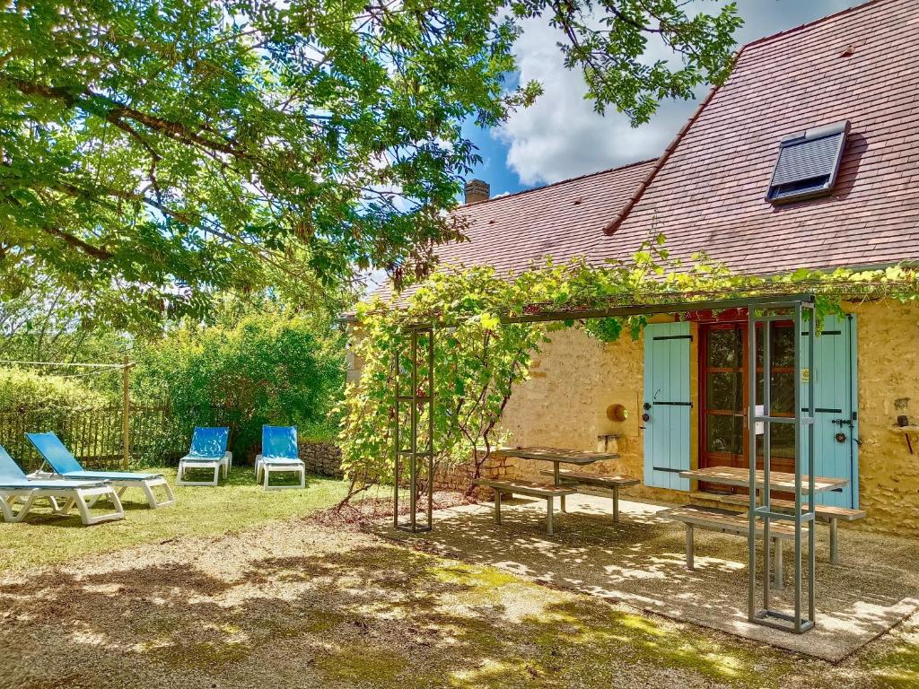 a house with two chairs and a bench in the yard at Domaine De Vic in Saint-Chamassy