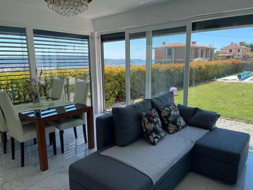 a living room with a couch and a table with a view at Počitniška hiška SEA HIDEAWAY in Ankaran