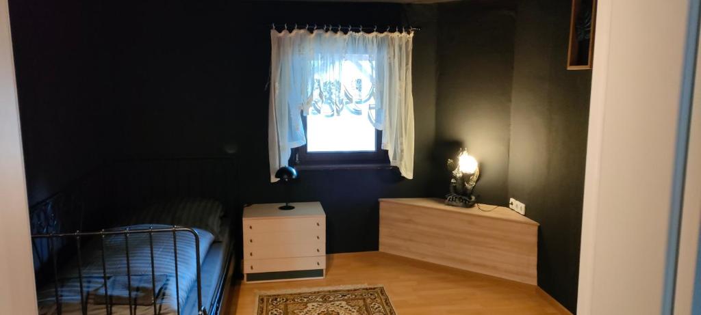a bedroom with a bed and a window and a dresser at Käfer D in Waldbrunn