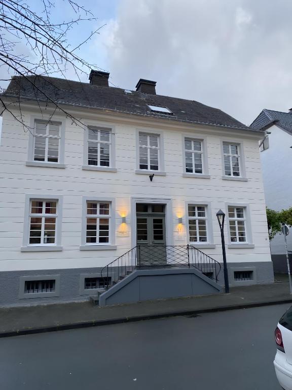 a white house with a staircase in front of it at Ferienwohnung Dora Brand in Arnsberg