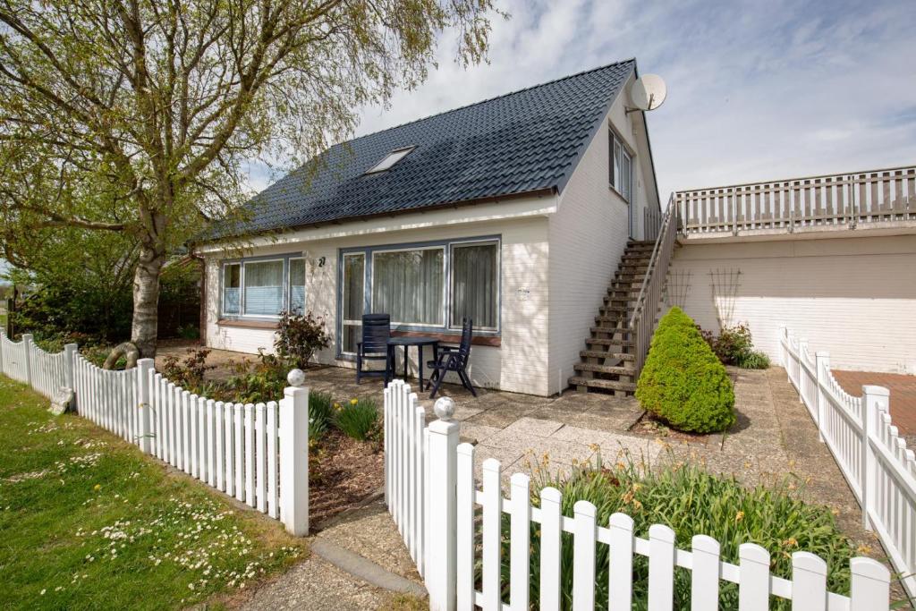 a white fence in front of a white house at Vogelhus Yvonne Vogel in Pellworm