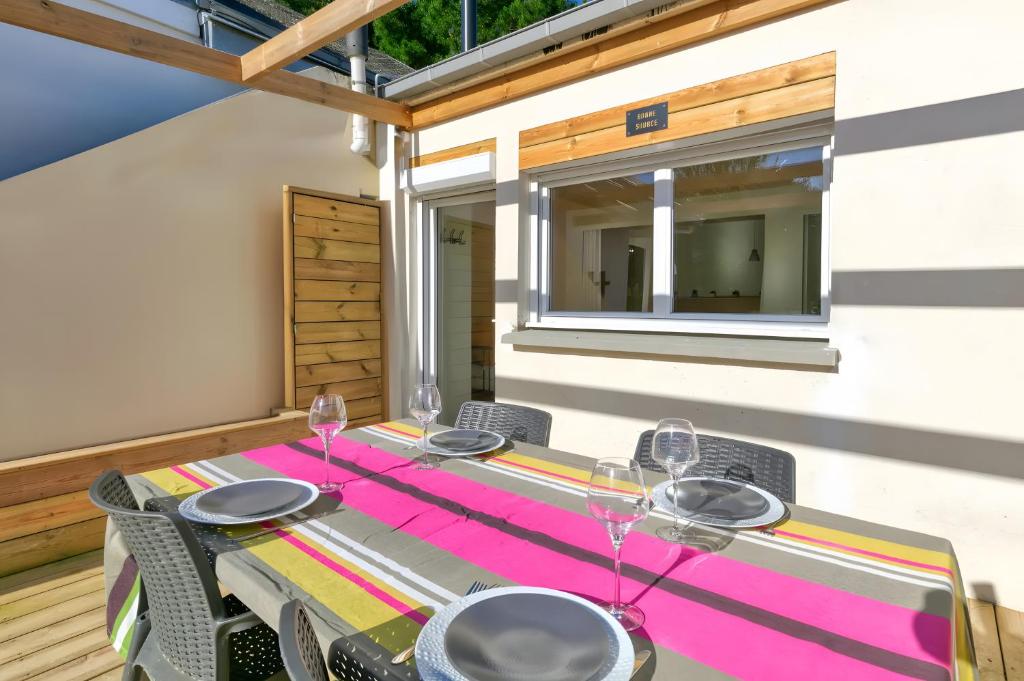 a table with chairs and glasses on a patio at La Dune de Sable - Cavaro in Pornichet