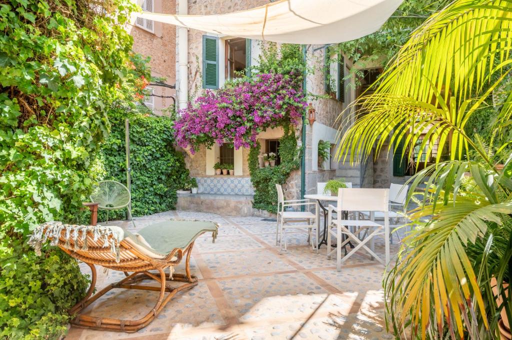 a patio with a table and chairs and flowers at Ca Sa Mar in Sóller