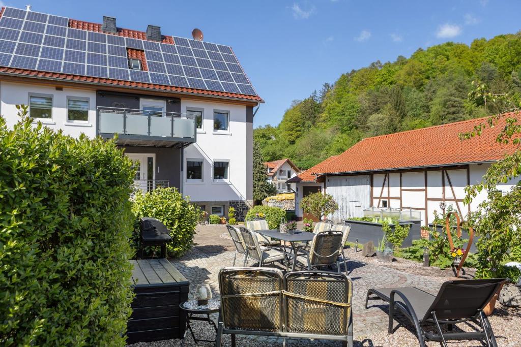 a patio with a table and chairs and solar panels at Mentel´s Ferienwohnung in Knüllwald