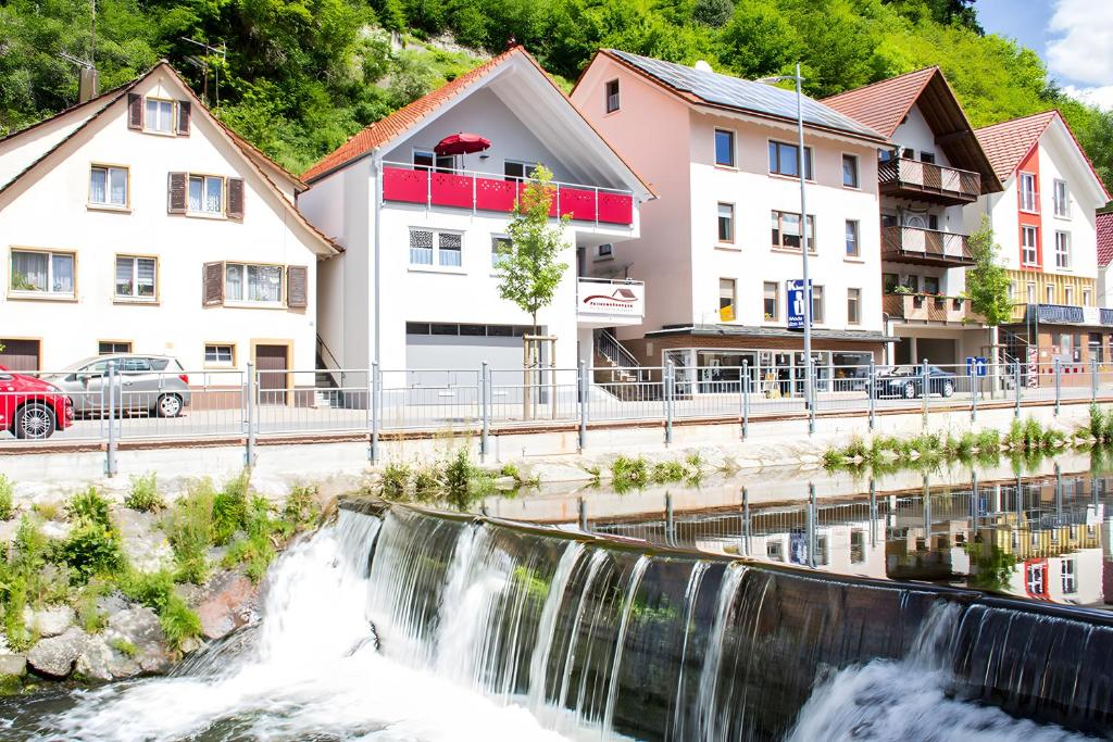 a waterfall in the middle of a town with houses at Ferienwohnungen Beilerstädtle in Oppenau