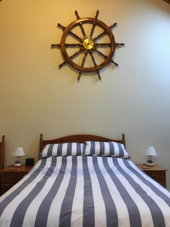 a bedroom with a bed with a wooden wheel on the wall at The Waterings in St. Davids
