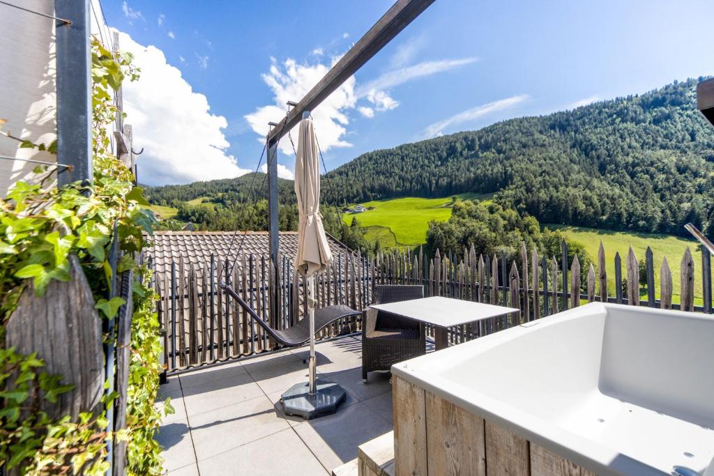 a view from the balcony of a house with a table and an umbrella at Sonnleiten Sterngucker 10 in Collepietra