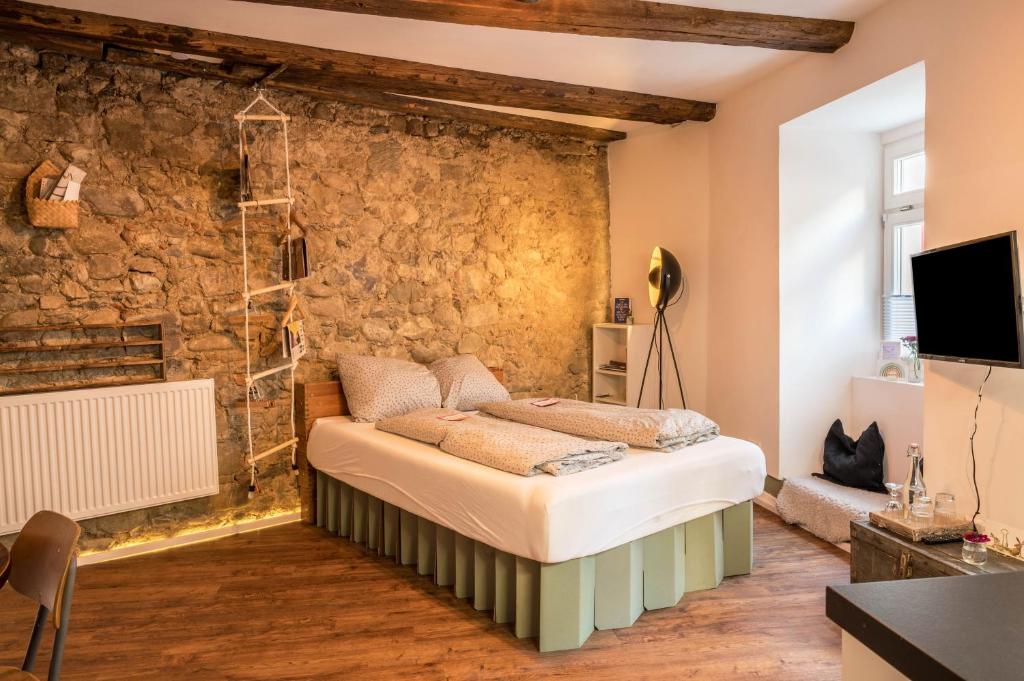 a bedroom with a bed in front of a stone wall at Fewo Sankt Johann I in Konstanz