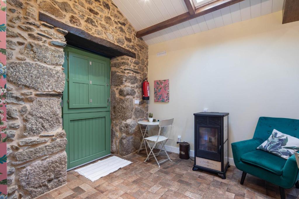 a room with a green door and a stone wall at La Caseta De Laura in Arzúa