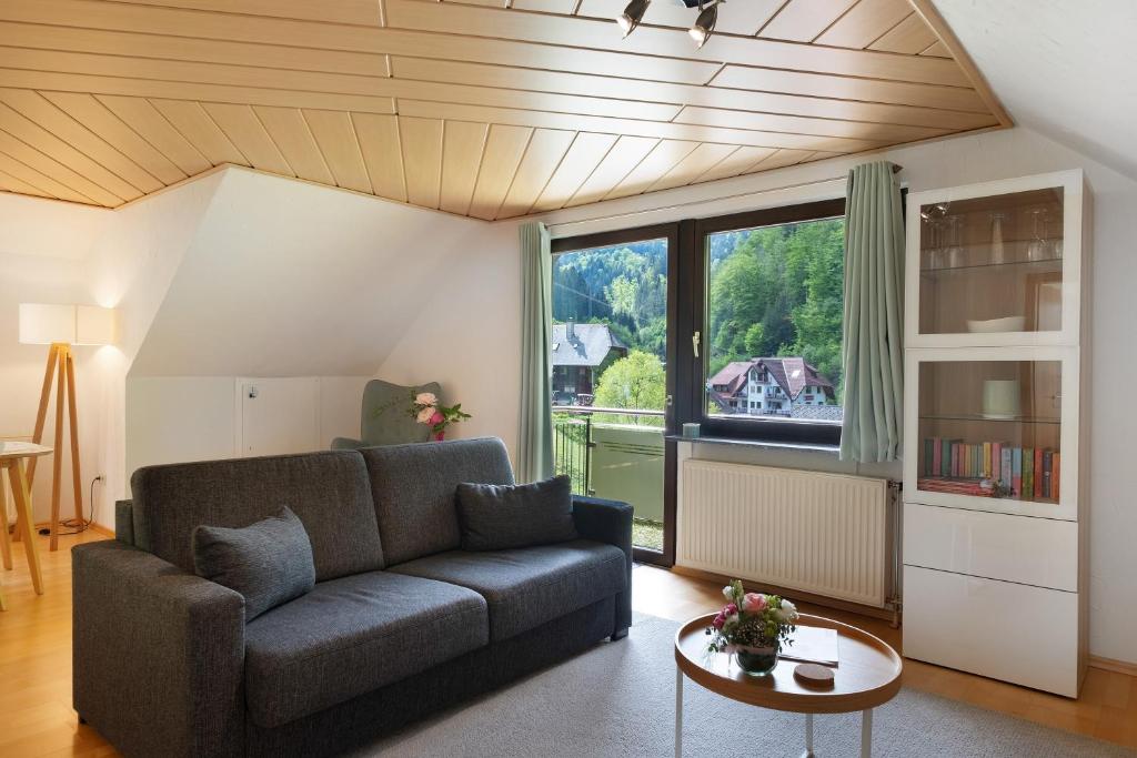 a living room with a couch and a large window at Ferienwohnung Glashütte in Sankt Märgen