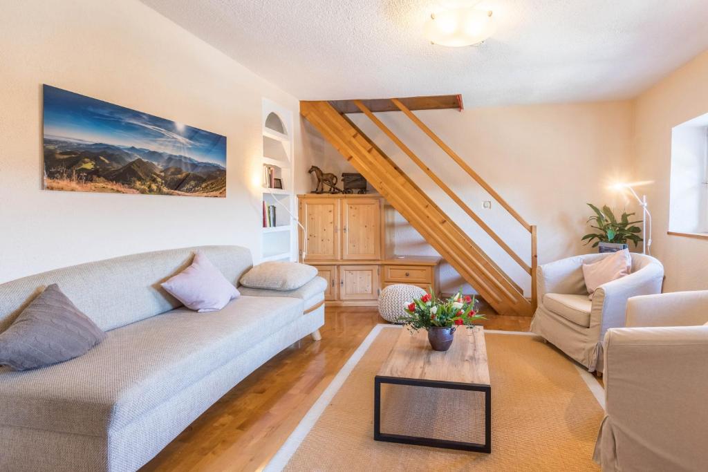 a living room with a couch and a table at Uriges Landhäuschen in Siegsdorf