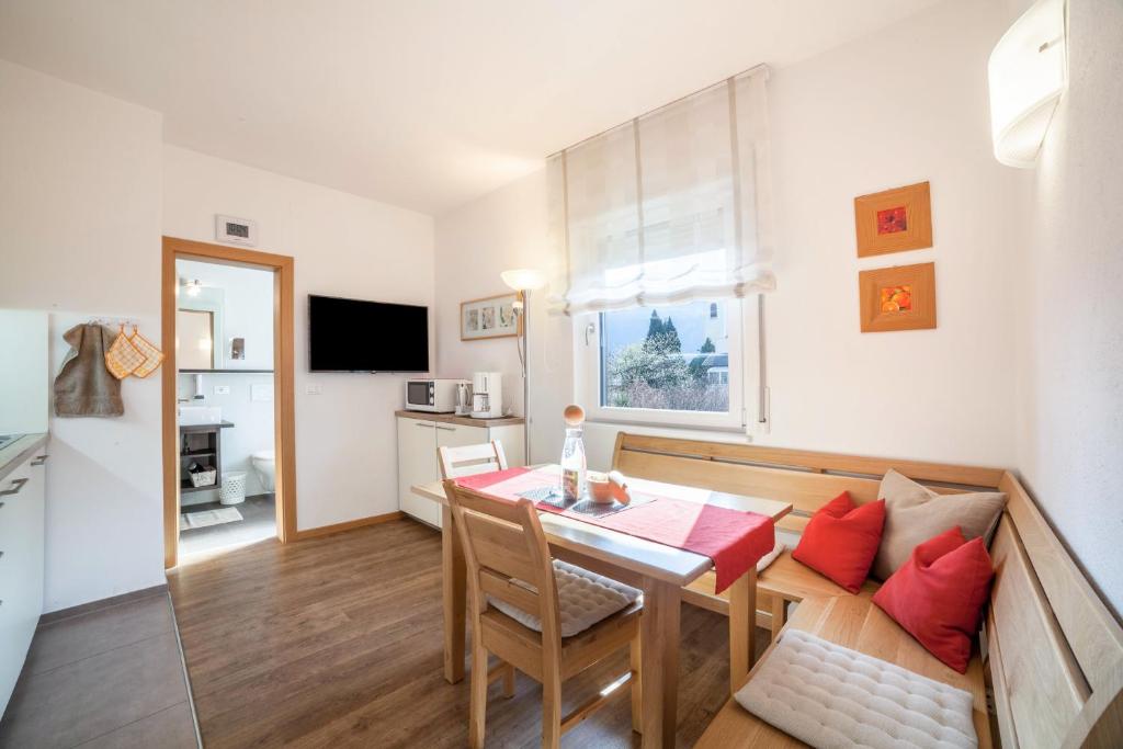 a living room with a table and a dining room at Schnitzer Ferienwohnung Hagebutte in Rablà