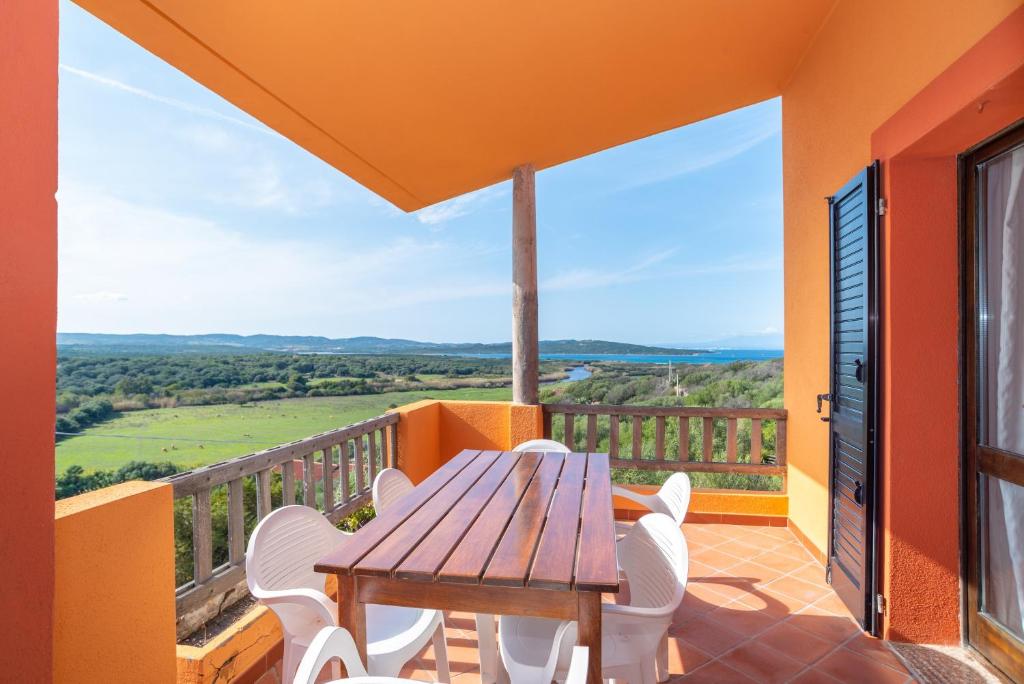 a wooden table and chairs on a balcony with a view at Conchiglia Blu in Barrabisa