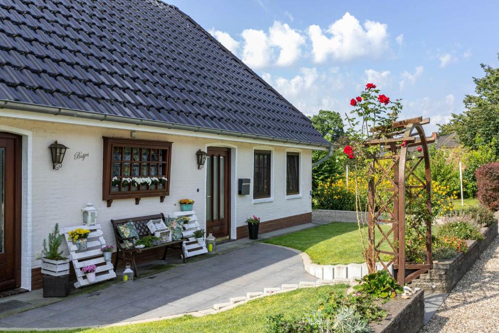 a small white house with a patio and a garden at Ferienwohnung Butjes in Sollwitt