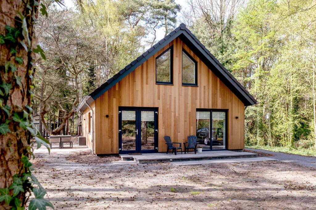 a house in the woods with two chairs at Casa Allocco in Norg