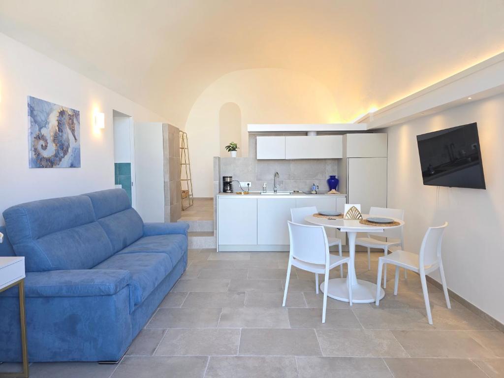 a living room with a blue couch and a table at Syrenia Home in Vico Equense