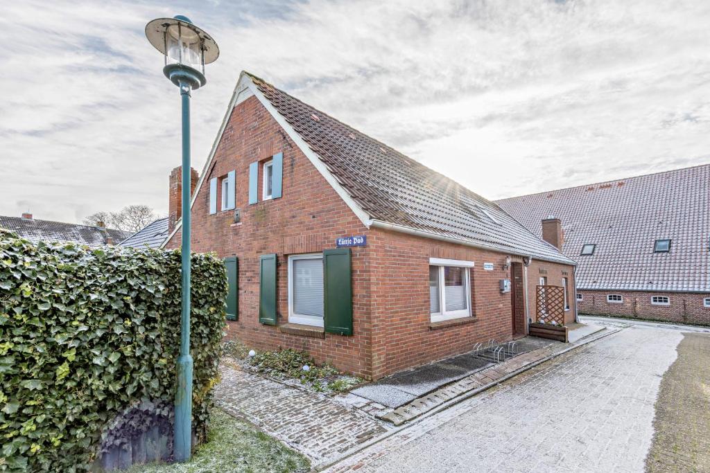 a brick house with a street light in front of it at Ferienhaus Grietjes Huus in Krummhörn