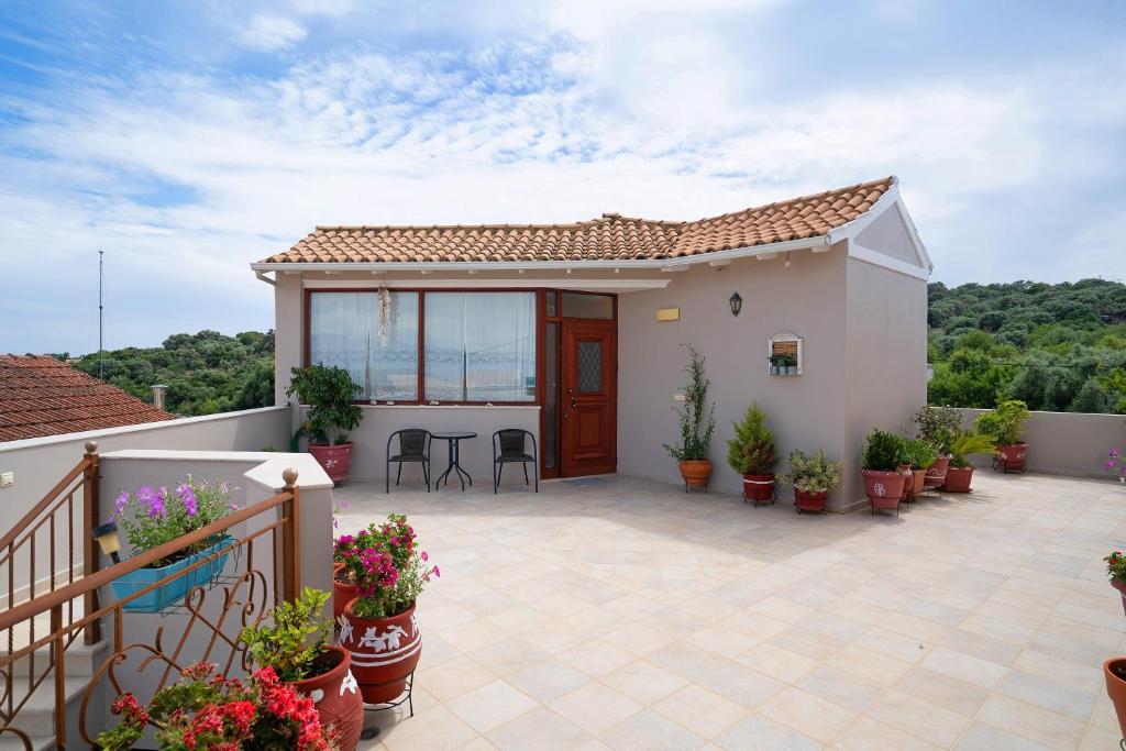 a house with a patio with potted plants at Lakis Apartment in Meganisi