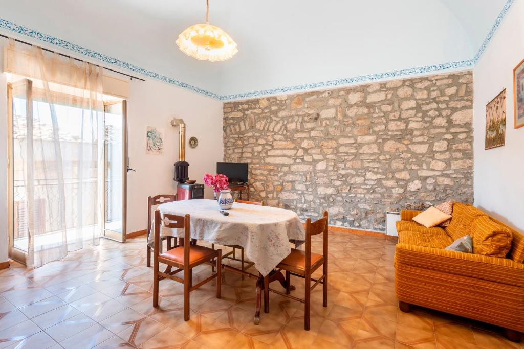 a living room with a table and chairs and a couch at Il Baglio Antico in Prizzi