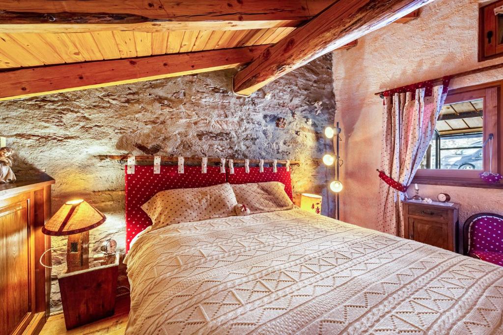a bedroom with a bed with a red head board at Arpy an in Morgex