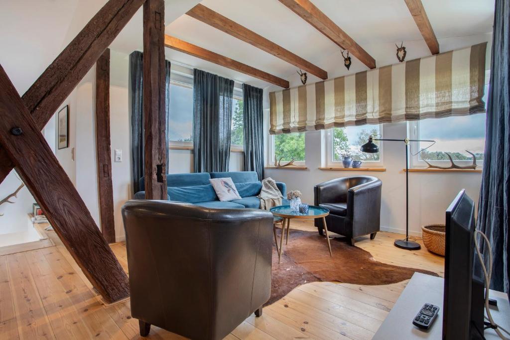 a living room with a blue couch and a table at Taubenkobel in Groß Wokern