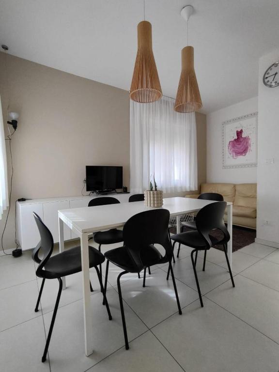 a dining room with a white table and black chairs at Apartment Mare Caorle int 1 in Caorle