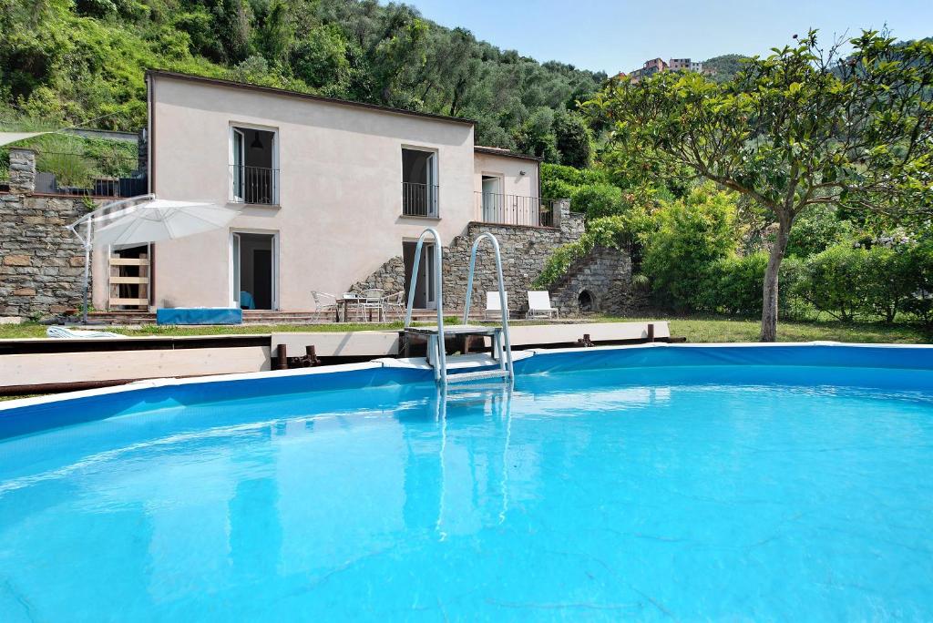 a large blue swimming pool in front of a house at Villa Nespolo in Levanto