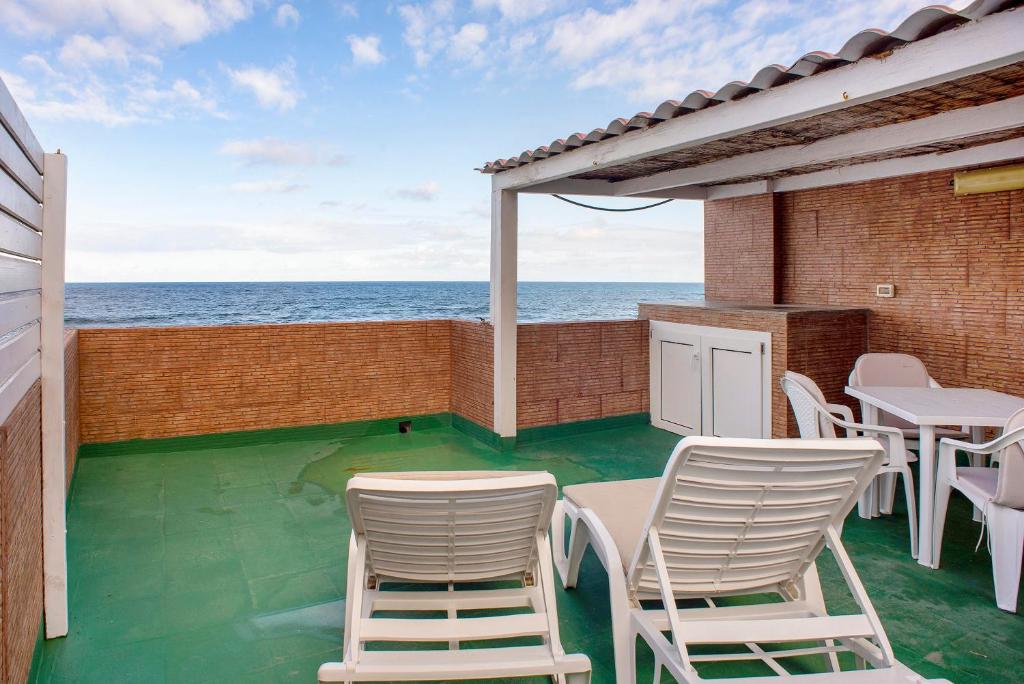 a patio with chairs and a table and the ocean at Las Sales Duplex in Moya