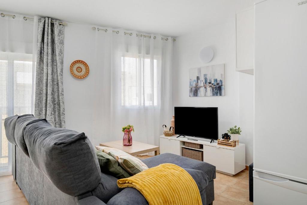 a living room with a couch and a tv at Campo Amor Alto in Arrecife
