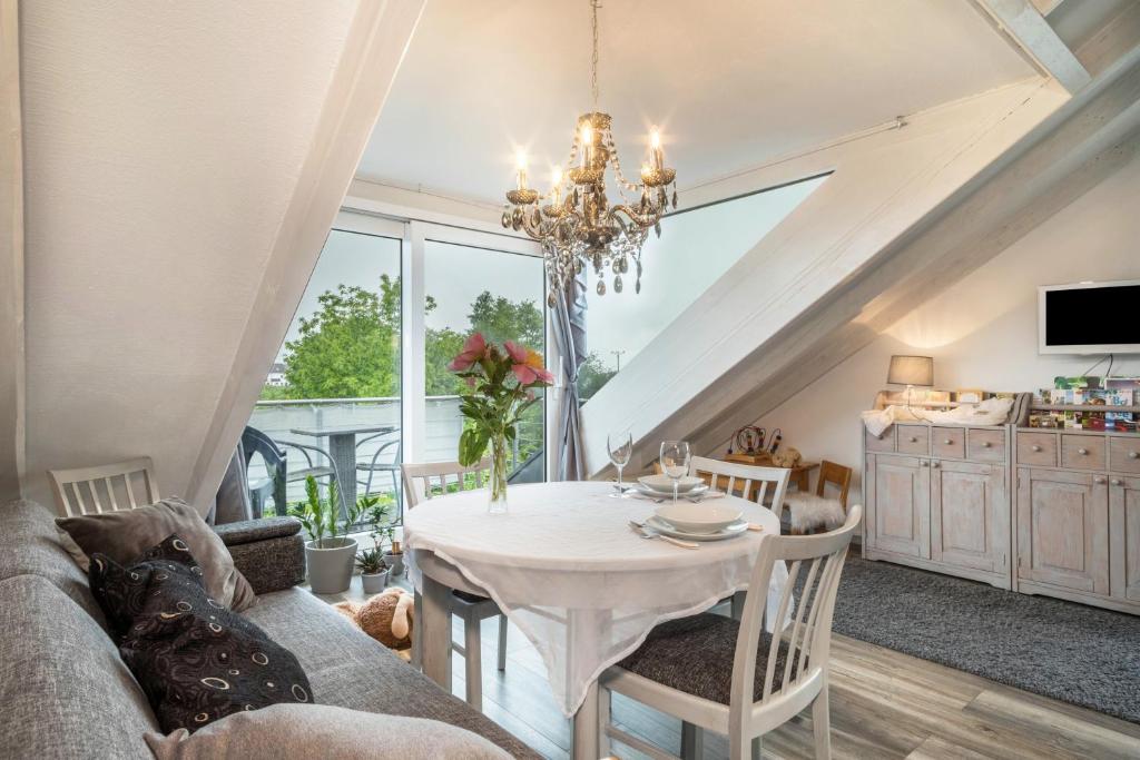 a living room with a table and a chandelier at Straub in Meckenbeuren