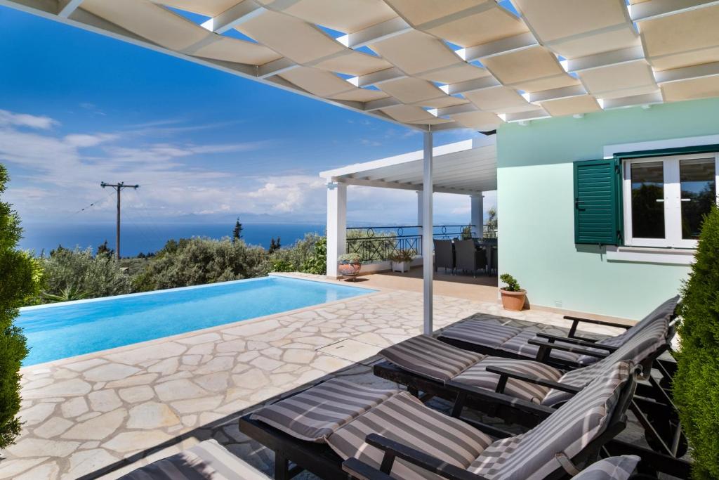 a patio with lounge chairs and a swimming pool at Villa Belvedere Verde in Lefkada
