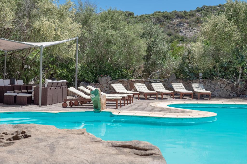a pool with chaise lounge chairs and a swimming pool at Villa Rosa in Porto Rotondo