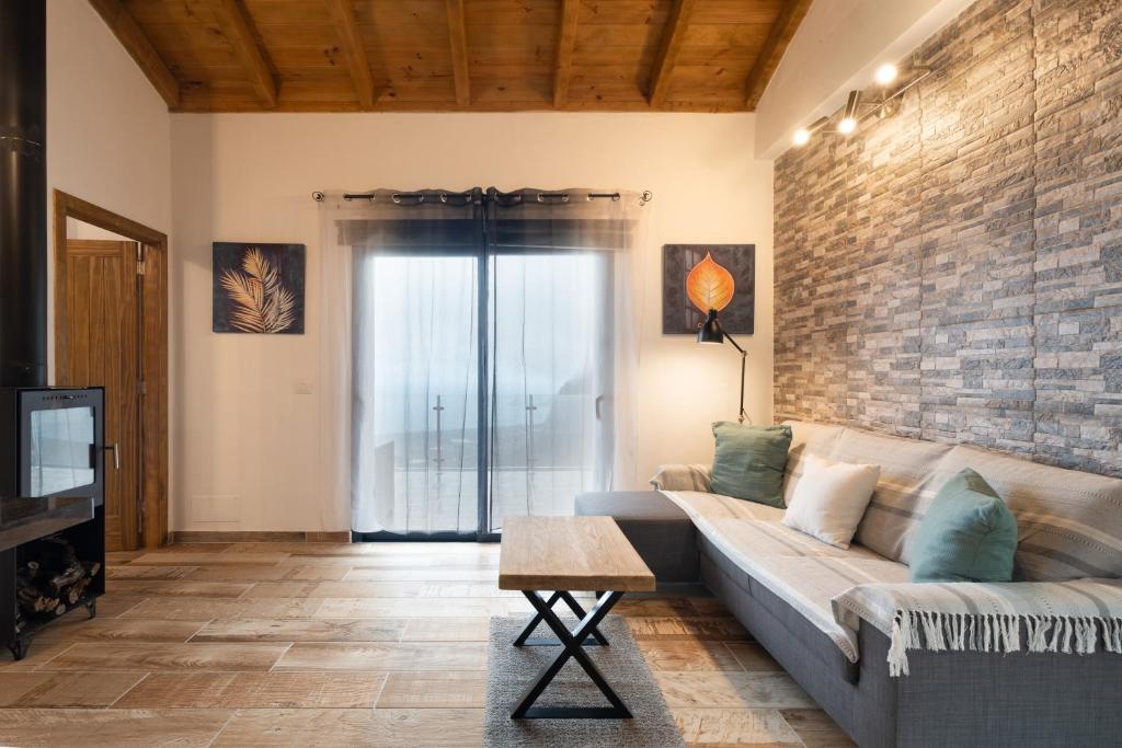 a living room with a couch and a brick wall at Los Almendr2s in Frontera