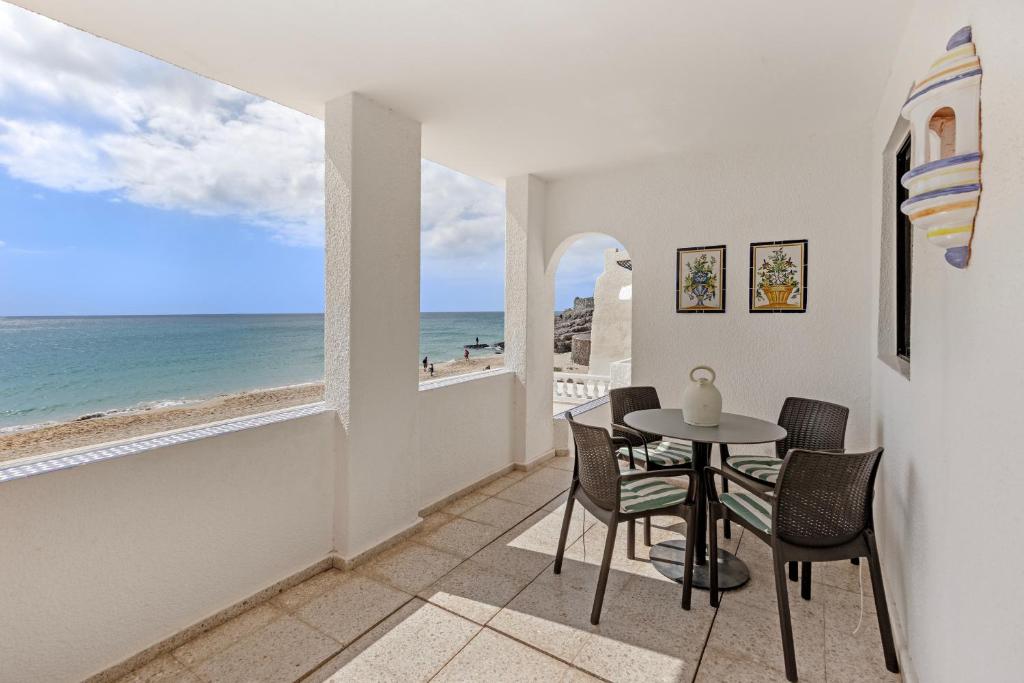 a dining room with a table and chairs and a view of the ocean at Beach House Christine in Costa Calma